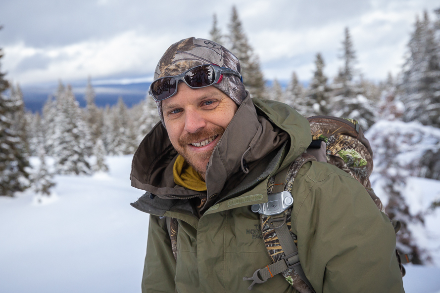 Portrait de Mathieu Hänni, l'un des accompagnateurs de Pérégrinatures sur fond de Jura enneigé.